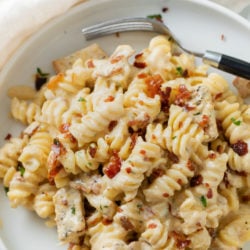 A labeled image of Chicken Bacon Spinach Pasta with a fork on a white plate.
