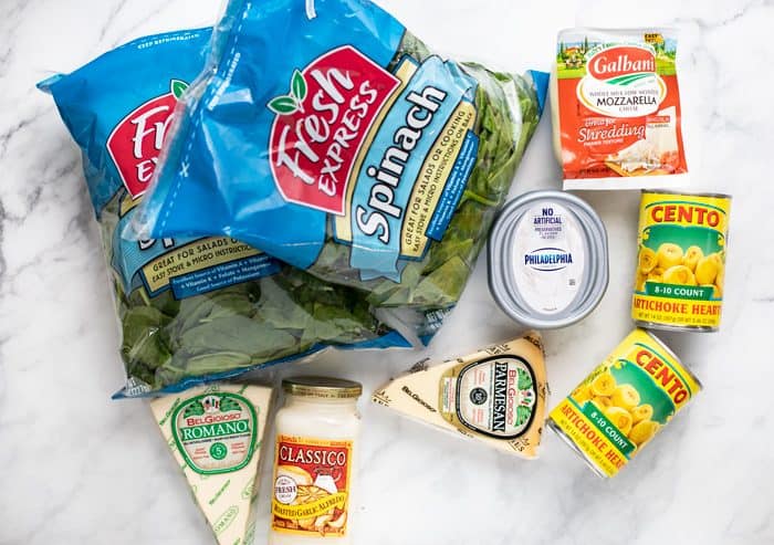 This ultra-creamy Spinach and Artichoke Dip tastes just like the Applebee's version! It's easy to make at home in under 30 minutes, just combine the ingredients until melted! This is perfect with tortilla chips, pita chips, crusty Artisan breads, and vegetables! | The Cozy Cook | #appetizer #dip #applebees #copycat #spinach #artichoke Ingredients needed to make spinach and artichoke dip recipe on a white granite countertop