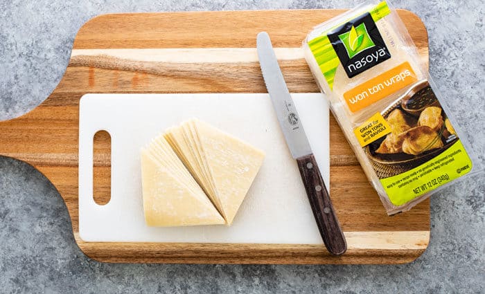 wonton wraps on a wooden cutting board next to the package.