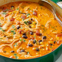 A green soup pot filled with creamy Chicken Enchilada Soup.