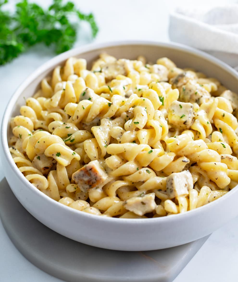 White Cheddar Chicken Pasta with spiral pasta in a white bowl.