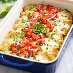 White Chicken Enchiladas with a creamy white sauce, cheese, and colorful toppings.