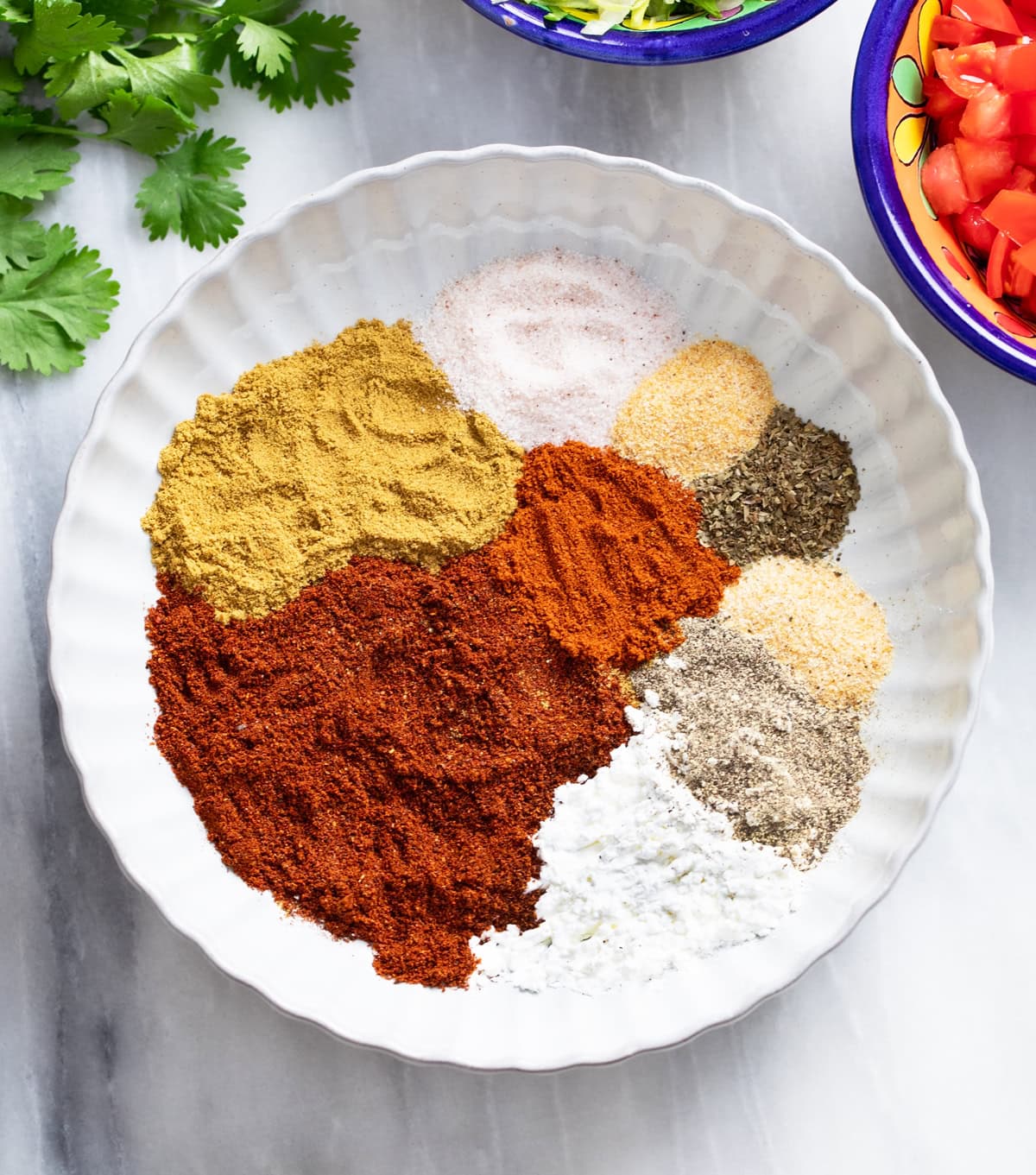 Taco seasonings in a white bowl before being combined together.